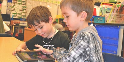 two students using a tablet in the classroom